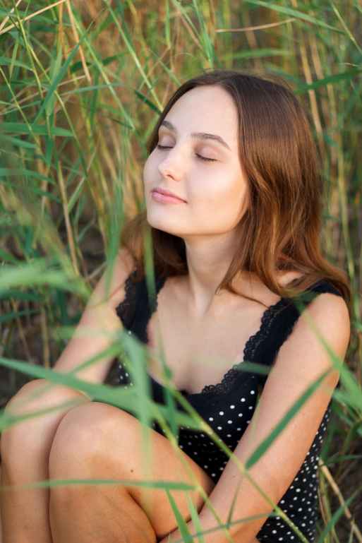 photo of woman sitting on green grass