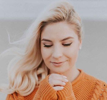 blonde haired woman in orange knitted long sleeved top